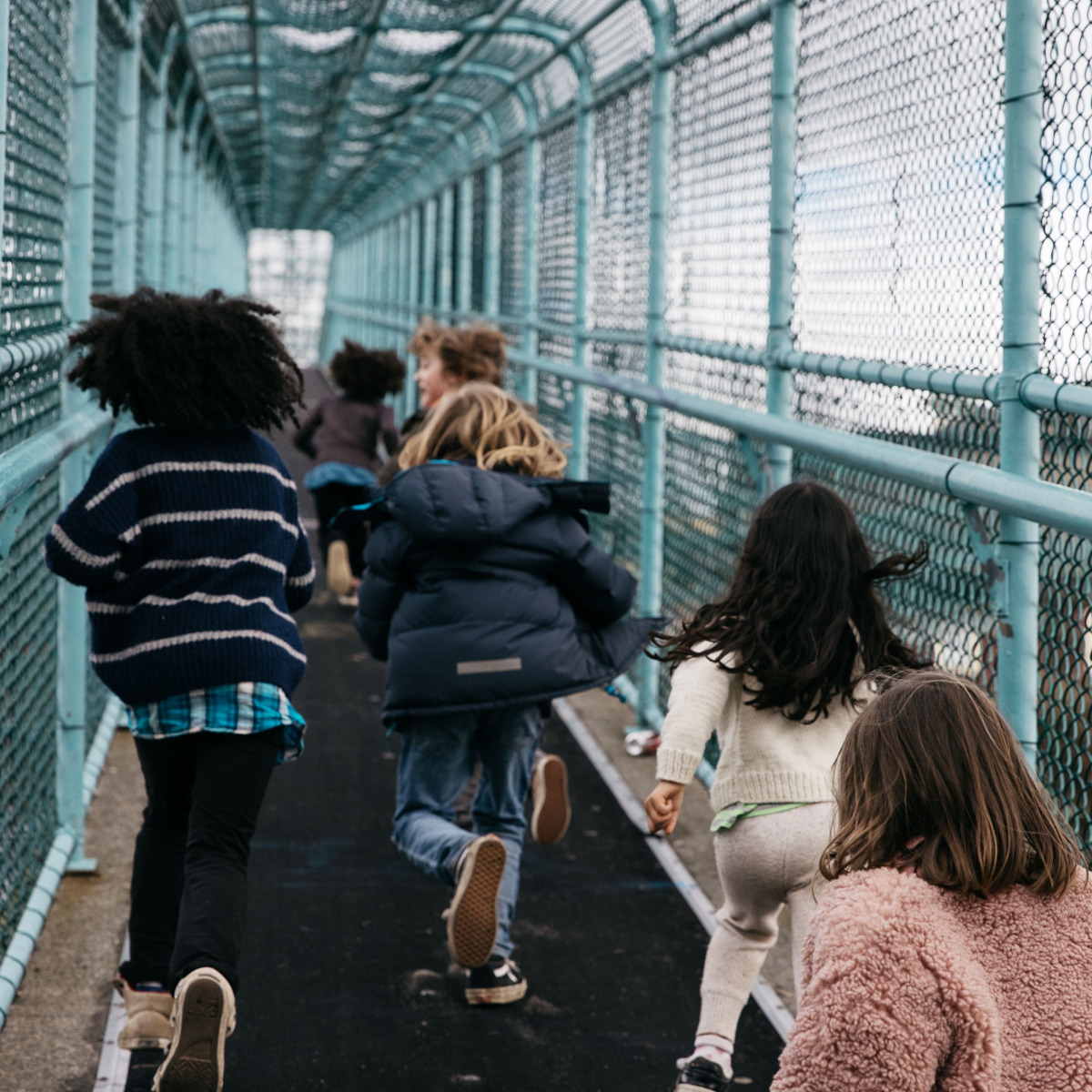 Children running across a bridge